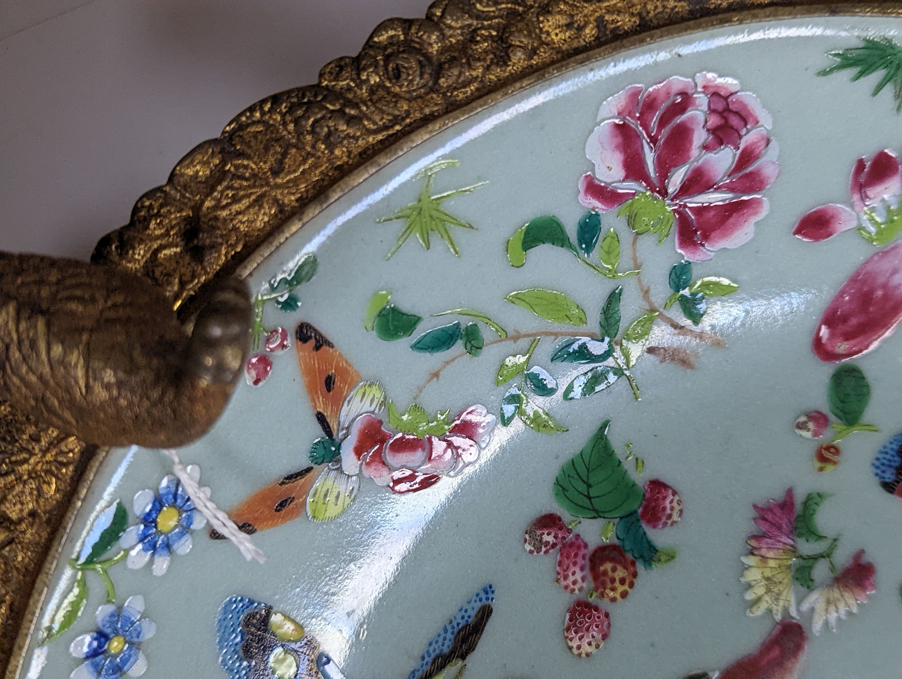 A 19th century Chinese famille rose dish with ormolu mount, 29 cms diameter.